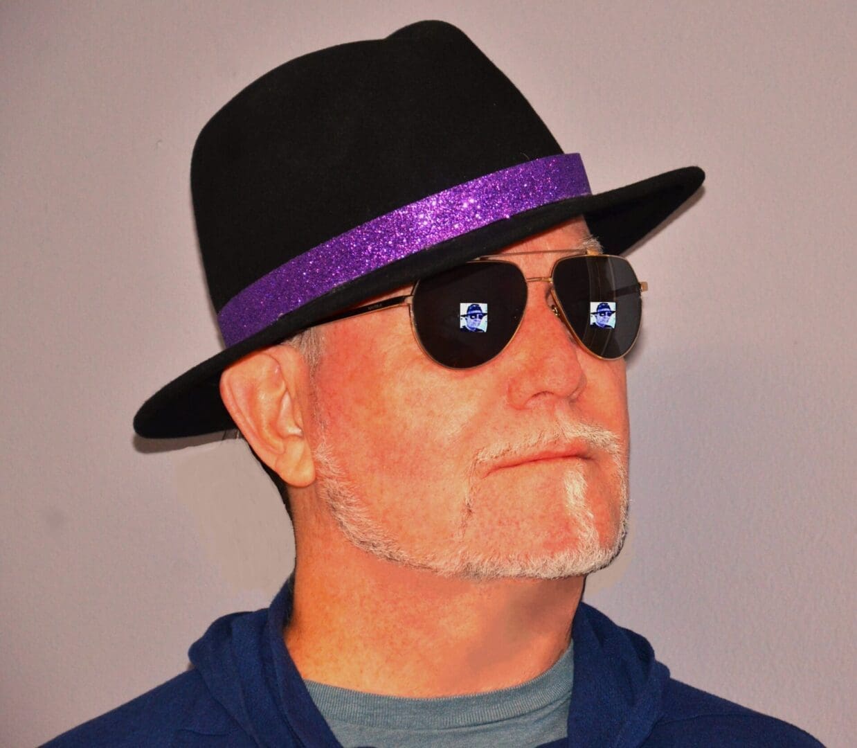A man with sunglasses and a hat on.